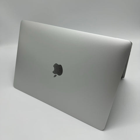 Händer som skriver på en MacBook Pro i ett upplyst rum.